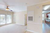 This single-floor residence presents a thoughtfully designed layout with a cohesive neutral color palette of warm beige and cream tones throughout. The living area features plush wall-to-wall carpeting, crown molding, and a ceiling fan, with direct sightlines to both the kitchen and additional rooms, fostering an open and connected feel. Natural light filters through multiple blinds-fitted windows across the home.

The dining area is distinguished by elegant tile flooring, a classic chandelier, and a chair rail that adds architectural detail to the walls. It connects seamlessly to the kitchen, which is equipped with rich medium-toned wood cabinetry, granite countertops, a stainless steel sink, and a dishwasher. A tall window in the kitchen area brings in outdoor views and natural light.

The bedrooms are carpeted and feature pendant lighting fixtures, windows admitting natural light, and access to closets. The bathroom includes tile flooring, a tub/shower combination, a rich wood vanity with a granite countertop, and a mirrored medicine cabinet. White panel doors and consistent trim work unify the overall design, contributing to the home's clean, well-maintained character.