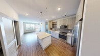 This contemporary apartment, located at 13280 Woodland Park Rd. in Herndon, VA, offers 950 square feet of thoughtfully designed living space. The floor plan includes two bedrooms, two full bathrooms, and an open-concept living area. The primary bedroom is generously sized at 140 square feet, providing ample space for comfort and relaxation.

The heart of the home is the modern kitchen, featuring sleek cabinetry, stainless steel appliances, and a stylish brown tile backsplash. A large kitchen island with a light-colored quartz countertop serves as both a functional workspace and casual dining area. Pendant lighting adds a touch of elegance to the space.

Throughout the apartment, you'll find high-quality vinyl plank flooring that mimics the look of hardwood, creating a warm and inviting atmosphere. The living room boasts large windows and a glass door leading to a private balcony, offering urban views and allowing natural light to flood the space.

Both bedrooms feature spacious closets with custom-built organizers, maximizing storage efficiency. The bathrooms are well-appointed with modern fixtures, including a floating vanity and a glass-enclosed shower in the ensuite.

The apartment's neutral color palette, clean lines, and contemporary design elements create a sophisticated and versatile living environment, perfect for modern urban living.