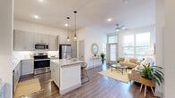 Located at 174 College Park Dr in Weatherford, TX, this well-appointed 2-bedroom, 2-bathroom residence offers a thoughtfully designed single-floor layout. The open-concept living area seamlessly connects the kitchen, dining, and living spaces, creating an inviting and functional environment. The kitchen is a standout feature, boasting gray shaker-style cabinetry, granite countertops, a subway tile backsplash, a central island with pendant lighting, and a full suite of stainless steel appliances. A built-in desk area provides a convenient workspace just off the kitchen. The living room is bathed in natural light from floor-to-ceiling windows and features wood-look flooring and a ceiling fan. Both bedrooms are bright and comfortable, with large windows and wood-look floors. The primary bedroom benefits from a spacious walk-in closet with built-in shelving and hanging rails. The bathrooms are finished with granite vanity tops, gray cabinetry, and elegant tile flooring. Additional highlights include four closets for ample storage, a dedicated laundry area, and a private patio. The overall aesthetic is clean, modern, and bright throughout.