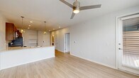 Located at 11110 Lantern Rd in Fishers, Indiana, this one-bedroom, one-bathroom residence offers a well-designed, single-floor layout that maximizes every square foot. The open-concept living and kitchen area serves as the heart of the home, featuring light hardwood-style flooring, recessed lighting, and a modern ceiling fan. The kitchen is outfitted with warm-toned cabinetry, white quartz countertops, a subway tile backsplash, stainless steel appliances including a dishwasher and refrigerator, and a peninsula with pendant lighting that doubles as a breakfast bar. Built-in open shelving provides additional storage and display space. The living area is bright and airy, benefiting from natural light streaming through large windows. The bedroom is carpeted for comfort and includes a ceiling fan, generous windows with outdoor views, and access to a spacious walk-in closet equipped with wire shelving systems. The bathroom features a full tub-shower combination, a dark-cabineted vanity with a light countertop, and hardwood-style flooring that ties the space together. Throughout, the neutral color palette and clean finishes create a fresh, modern ambiance suited for comfortable everyday living.