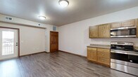 Located at 2040 Prairie Rose Dr in Mankato, MN, this one-bedroom, one-bathroom unit offers a practical and comfortable layout across a single floor. The open-concept kitchen and living area serves as the heart of the home, featuring warm oak cabinetry with granite-style countertops, stainless steel appliances including a range, microwave, dishwasher, and a French door refrigerator with water dispenser. Wood-look vinyl plank flooring runs throughout the main living areas, adding a clean, modern touch. Six-panel wood doors lend a classic architectural detail throughout the unit. The bedroom is a cozy retreat finished with plush wall-to-wall carpeting, a tray ceiling that adds subtle dimension, and a window offering neighborhood views and natural light. The bathroom includes a full-size soaking tub and shower combo with clean white surrounds and wood-look flooring. Two closets provide ample storage, while a dedicated laundry area and utility room add everyday convenience. A private balcony extends the living space outdoors. The overall ambiance is clean, functional, and move-in ready, making it a solid option for those seeking comfortable living in Mankato.