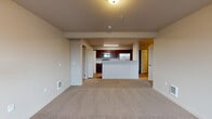 Located at 352 North Beck Road in Post Falls, Idaho, this single-floor unit offers a well-designed layout with functional living spaces throughout. The open-concept living and dining area is finished with plush neutral carpeting and connects seamlessly to the kitchen, creating an inviting, cohesive space. A window allows natural light to brighten the living area, which also features a wall-mounted climate control unit for year-round comfort.

The kitchen is appointed with rich, dark-toned cabinetry, light-colored countertops, and a full suite of stainless steel appliances, including a refrigerator, over-the-range microwave, and a black electric range. A kitchen island provides additional prep and serving space. Wood-look flooring runs throughout the kitchen and wet areas, adding warmth and easy maintenance.

The bedrooms are carpeted and generously sized, each offering access to closet space with built-in shelving and hanging rods. The primary bathroom features a dual-sink vanity with rich cabinetry, a large mirror, and wood-look flooring, while a secondary bathroom includes a soaking tub and single vanity. A dedicated laundry area accommodates a full-size washer and dryer, adding everyday convenience to this practical and comfortable home.