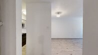 Located at 6000 Boca Raton Blvd in Fort Worth, TX, this single-floor, one-bedroom, one-bathroom unit offers a well-organized layout across a compact yet functional floor plan. Light wood-style flooring runs throughout, complementing the bright white walls and textured ceilings found in most rooms.

The combined kitchen and living room serves as the heart of the unit. The living area features a wood-burning fireplace flanked by a window with blinds, filling the space with natural light. Built-in shelving adds a practical storage accent along one wall. The kitchen is defined by a raised breakfast bar pass-through, gray cabinetry with brushed nickel hardware, white countertops, and stainless steel appliances including a refrigerator and microwave.

The spacious primary bedroom offers a comfortable footprint with a window providing natural light, direct access to the bathroom, and a separate closet. The bathroom includes a wide vanity with white countertops, under-sink cabinetry, a large mirror, and stylish light fixtures. A hallway connects the main living areas to the private bedroom and bathroom, ensuring a logical flow throughout the unit.