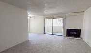 Located at 1517 3rd St in Sacramento, CA, this single-floor apartment offers 790 square feet of living space across 2 bedrooms and 2 bathrooms. The open living area features plush carpeting, a ceiling fan, a wood-burning fireplace, and a sliding glass door with vertical blinds that allows for natural light and outdoor access. The adjacent kitchen is equipped with white cabinetry, a peninsula countertop, a white refrigerator, an electric range, and a window with vertical blinds that brings in additional natural light. Both bedrooms are carpeted with textured ceilings and feature sliding closet doors with built-in shelving and hanging rods. The primary bedroom, measuring 180 square feet, includes direct access to one of the two bathrooms. Both bathrooms feature light wood-style vinyl flooring, vanity cabinetry, and a separate water closet with a toilet. The unit also includes a hallway and an additional closet for extra storage. Neutral tones throughout the apartment create a clean, functional aesthetic well-suited for everyday living in the heart of Sacramento.