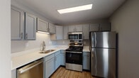 Located at 211 Starlet Ct in Louisville, Kentucky, this single-story home offers a well-designed layout with functional living spaces throughout. The kitchen is a standout feature, showcasing grey shaker-style cabinetry with brushed nickel hardware, crisp white countertops, and a full suite of stainless steel appliances including a gas range, over-the-range microwave, dishwasher, and refrigerator. Wood-look luxury vinyl flooring ties the kitchen together with a clean, contemporary feel, complemented by flush panel ceiling lighting. The bedrooms are generously proportioned, each featuring plush carpeting, neutral grey wall tones, ceiling fans with light fixtures, and windows that invite natural light and views of surrounding greenery. The layout visible from the dollhouse view reveals an open, connected flow between the living and kitchen areas, with clearly defined bedroom spaces. The bathroom is outfitted with wood-look tile flooring, a tub-shower combination, a grey vanity with a white countertop, and coordinating cabinetry for ample storage. Consistent neutral tones and modern finishes throughout create a cohesive, move-in-ready atmosphere across the entire home.