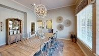 This thoughtfully designed single-floor home showcases an exceptional blend of elegance and functionality throughout its well-appointed spaces. Striking herringbone-patterned hardwood flooring flows consistently throughout, tying each room together with a sophisticated, cohesive aesthetic.

The expansive living room serves as the heart of the home, boasting soaring ceilings, a dramatic bay window arrangement that floods the space with natural light, and a stone fireplace flanked by a wall-mounted television. A globe chandelier and recessed lighting complement the airy, open atmosphere. The formal dining room echoes this refined style, featuring a large farmhouse-style dining table beneath a matching orb chandelier, with wide windows offering outdoor views and decorative wall accents that add artistic character.

The butler's pantry is a standout feature, showcasing quartz countertops, grey cabinetry, open wood shelving with ornate brackets, a patterned tile accent wall, and an integrated beverage refrigerator — a perfect blend of practicality and design flair.

A dedicated office or business center provides a functional workspace with a long wooden worktable, wall-mounted display screen, and ample storage. A welcoming sitting area near the entry features soaring walls, herringbone floors, and carefully curated décor, creating an inviting first impression throughout this elegantly appointed home.