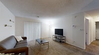 Located at 1752 Willis St in South Bend, Indiana, this one-bedroom, one-bathroom residence is thoughtfully laid out across a single floor, making efficient use of its cozy footprint. The living room features plush carpeting, a textured ceiling, and a large sliding glass door dressed with vertical blinds that allows natural light to fill the space. The dining area is situated adjacent to the living room and is highlighted by a ceiling fan with integrated lighting and a full wall of mirrored panels that visually expand the room. The kitchen is equipped with white cabinetry, dark granite-style countertops, black appliances including a refrigerator, range, dishwasher, and microwave, along with light wood-look flooring that adds warmth and contrast. The bedroom offers comfortable carpeting, a window with blinds for natural light, and a mirrored sliding-door closet that provides ample storage while enhancing the sense of space. The bathroom includes a vanity with a dark countertop, a framed mirror, and a shower-tub combination. Throughout the residence, neutral tones and consistent finishes create a clean, cohesive aesthetic well-suited for comfortable everyday living.