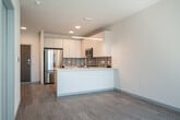 Located at 5022 American Pkwy in Madison, WI, this well-appointed one-bedroom, one-bathroom unit offers a thoughtfully designed, single-floor layout with a clean, contemporary aesthetic throughout. Light-toned luxury vinyl plank flooring flows seamlessly across the entire space, complementing the bright, neutral palette on every wall.

The open-concept kitchen and living area serves as the heart of the unit. The kitchen is outfitted with floor-to-ceiling white cabinetry, quartz countertops, a textured tile backsplash, and a full suite of stainless steel appliances including a refrigerator, range, microwave, and dishwasher. A peninsula with a single-basin sink and pendant lighting above doubles as a breakfast bar, connecting the kitchen naturally to the living area. Sliding glass doors in the living room open to a private balcony overlooking the landscaped courtyard and surrounding community.

The bedroom is a comfortable, well-proportioned retreat featuring a window with blinds that admits natural light and views of the exterior. The bathroom includes a glass-enclosed walk-in shower with chrome fixtures and tile surround. Additional highlights include three closets for generous storage, an in-unit laundry area, and a ceiling fan in the bedroom. The unit presents a polished, move-in-ready environment ideal for modern living.