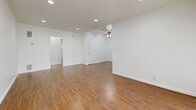 Located at 7550 Fountain Ave in the heart of West Hollywood, CA, this one-bedroom, one-bathroom unit offers a well-designed single-floor layout that maximizes every square foot of its modest footprint. Rich, warm-toned hardwood-style flooring runs throughout the entire unit, creating a cohesive and inviting atmosphere from room to room.

The open living area is bright and airy, featuring recessed lighting, clean white walls, and vertical blinds that allow for natural light control. A ceiling fan with a light fixture adds both style and comfort. The space flows naturally into a hallway connecting the remaining rooms.

The galley-style kitchen is thoughtfully appointed with white shaker cabinetry, grey quartz countertops, a classic subway tile backsplash, and stainless steel appliances including a gas range, microwave, and refrigerator — offering a modern, functional cooking space.

The bedroom is a comfortable size, featuring its own ceiling fan, a window with vertical blinds, and a built-in closet with shelving for ample storage. The clean white walls keep the room feeling open and versatile.

The bathroom is finished with white hex tile flooring, a full soaking tub and shower combo, a single vanity with a grey countertop, and a window for natural ventilation. This unit combines clean, contemporary finishes with practical living in a prime West Hollywood location.