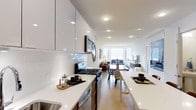 Located at 1133 Warburton Ave in Yonkers, NY, this 1-bedroom, 1.5-bathroom residence offers a thoughtfully designed single-floor layout with modern finishes and a bright, open feel. The kitchen is a standout feature, showcasing high-gloss white cabinetry extending to the ceiling, white quartz countertops, a classic subway tile backsplash, and stainless steel appliances including a gas range. Recessed lighting throughout enhances the clean, contemporary aesthetic. The kitchen flows seamlessly into the dining and living areas, creating an open-concept space ideal for both everyday living and entertaining. Light hardwood flooring runs throughout, lending warmth and continuity to the interior. The living area is bathed in natural light from large windows, creating an inviting and airy ambiance. A dining area with ample table space connects the kitchen and living room, making the layout both functional and social. The residence also includes a half bathroom in addition to the full bathroom, adding everyday convenience. The overall design emphasizes clean lines, neutral tones, and modern materials, resulting in a polished and move-in-ready home in the heart of Yonkers.