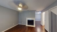 Located at 4720 Reading Rd in Rosenberg, Texas, this two-story home offers a thoughtfully designed layout spread across two levels. The main living area features rich, dark hardwood-style flooring and a standout fireplace with a white paneled surround, serving as the focal point of the room. A ceiling fan overhead and open sightlines into an adjacent space give the living area a comfortable, connected feel.

The kitchen is efficiently arranged with white cabinetry, granite-look countertops, a full suite of white appliances including an electric range and refrigerator, and an overhead ventilation hood. The cabinetry extends to the ceiling, maximizing storage throughout.

The primary bedroom is a highlight of the upper level, featuring vaulted ceilings, plush carpeting, a ceiling fan, and French doors that open to an outdoor view, filling the room with natural light. An en-suite bathroom includes a dual-mirror vanity with granite-look countertops and white cabinetry. Additional bedrooms also feature carpet flooring, ceiling fans, and generous windows.

Closet space is well-distributed, with walk-in and reach-in configurations visible throughout. A secondary bathroom features a clean vanity setup with ample counter space. Cool-toned gray walls throughout the home lend a consistent, neutral palette that complements the varied flooring and finishes across both floors.