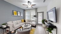 Located in Longwood, FL, this well-appointed 2-bedroom, 2-bathroom residence offers a thoughtfully designed single-floor layout. The open-concept living and kitchen area serves as the heart of the home, featuring light wood-style flooring, a bold slate-blue accent wall, and large windows that invite abundant natural light. A ceiling fan adds both function and style to the living space, which flows seamlessly to a private patio.

The kitchen is outfitted with crisp white shaker cabinetry, granite countertops, a full suite of stainless steel appliances, a subway tile backsplash, and a spacious central island with bar seating — ideal for casual dining and entertaining.

Both bathrooms are finished with granite vanity countertops, white cabinetry with matte black hardware, and tiled tub-shower combinations. The hallway connecting the bedrooms features soft carpet underfoot, providing a comfortable transition between spaces.

The primary bedroom is generously proportioned, with large windows offering outdoor views and ample natural light. Four closets throughout the residence provide exceptional storage. The overall aesthetic is clean and contemporary, with a cohesive neutral palette accented by modern fixtures throughout.