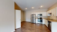 Located at 2217 Charlestown Rd in New Albany, Indiana, this single-floor unit offers a thoughtfully designed open-concept layout with clean, modern finishes throughout. The kitchen is a standout feature, equipped with a full suite of stainless steel appliances — including a gas range, over-the-range microwave, refrigerator, and dishwasher — complemented by white shaker-style cabinetry, granite-look countertops, and a stainless steel sink. Rich, dark hardwood-style flooring flows through the kitchen and living areas, creating a warm and cohesive aesthetic. The living area is generously proportioned, bathed in recessed lighting, and finished with a ceiling fan for year-round comfort. Bedrooms are carpeted for added warmth, each with windows that invite natural light and outdoor views. The bathrooms feature white vanities with extended countertop space, large mirrors, and matching hardwood-style flooring. A dedicated laundry room with hookups and shelving adds everyday convenience. Neutral-toned walls throughout the unit provide a versatile backdrop, and panel-style interior doors add a subtle architectural detail. This well-appointed space combines functional design with modern comfort in a move-in-ready setting.