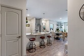 Located at 5403 W 96th Ave in Westminster, Colorado, this well-appointed 2-bedroom, 2-bathroom single-floor residence offers a thoughtfully designed open-concept layout. The combined kitchen, dining, and living area forms the heart of the home, where wood-look flooring flows seamlessly throughout. The kitchen is outfitted with rich dark-wood cabinetry, granite countertops, stainless steel appliances, a white subway tile backsplash, and a peninsula with bar seating illuminated by pendant lighting. The adjacent dining area and living room are bright and inviting, with large windows allowing ample natural light and a ceiling fan overhead. The spacious primary bedroom features plush carpet, a ceiling fan, and generous closet space with built-in rod storage. The second bedroom is equally comfortable with similar finishes and natural light. A shared bathroom corridor connects both bedrooms, featuring dark-wood vanity cabinetry with granite countertops. Additional conveniences include a dedicated laundry room with full-size washer and dryer, a utility room, a pantry, and three closets throughout. The overall ambiance is clean, modern, and functional, making this Westminster residence a comfortable and practical home.