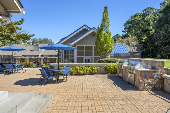 Espacio de entretenimiento al aire libre equipado con una estación de parrilla y abundantes asientos. - Windsor Peachtree Corners