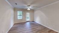 Located at 350 Amberleigh Bluff Way in Knoxville, Tennessee, this 2-bedroom, 2-bathroom single-floor residence offers a thoughtfully designed layout that balances comfort and functionality. Light-toned luxury vinyl plank flooring flows consistently throughout, lending a clean, cohesive aesthetic to the entire space.

The living room is a welcoming area featuring crown molding, a ceiling fan with light kit, and access to natural light through blinded windows and a glass-paneled door overlooking lush outdoor greenery. Adjacent to the living room, the dining area is defined by an elegant chandelier and additional crown molding, creating a refined setting for meals. The kitchen is well-equipped with dark espresso cabinetry, a double stainless steel sink, matching black appliances including a refrigerator with ice maker and an electric range, and track lighting overhead.

The spacious primary bedroom features large windows with outdoor views and a ceiling fan, while both bathrooms offer a consistent design with white vanity cabinetry, single-basin sinks, full tub-shower combinations, and light-reflecting mirrors. A dedicated closet provides additional storage. The hallway connects all rooms efficiently, contributing to the home's practical, open flow throughout.