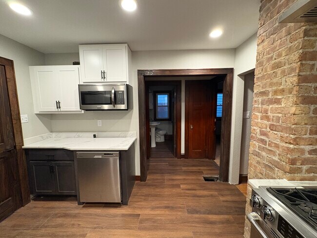 Cocina comunicada con el pasillo que da a los dormitorios y al baño. - 861 S 75th St