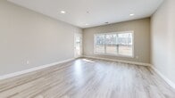 Located at 151 Hope Dr in Winchester, VA, this well-appointed 2-bedroom, 2-bathroom single-story residence offers a thoughtfully designed open-concept layout. The combined living, dining, and kitchen area serves as the heart of the home, featuring light hardwood-style flooring, recessed lighting, and large windows that flood the space with natural light. The kitchen is a standout, showcasing crisp white shaker cabinetry, granite countertops, stainless steel appliances, and a center island with pendant lighting — ideal for both cooking and entertaining. The living area provides a bright, airy atmosphere with direct access to a private patio, which features a brick knee wall and views of a shared outdoor green space with a covered pavilion. Both bedrooms are carpeted for comfort, with neutral tones and natural light from well-placed windows. The primary bedroom is generously proportioned and served by ample closet space. The bathrooms are clean and functional, with light wood-look flooring and a tub-shower combination. Additional highlights include a dedicated laundry area, multiple closets for storage, and a hallway connecting the private quarters to the main living spaces. The overall palette of soft grays and whites creates a modern, move-in-ready aesthetic throughout.