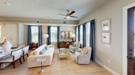 This well-appointed two-story home in Arlington, Texas offers four bedrooms and four bathrooms across two thoughtfully designed floors. The main level features an open-concept kitchen and living area bathed in natural light. The kitchen is a standout, boasting white shaker cabinetry, quartz countertops, stainless steel appliances, light hardwood flooring, and a large center island with seating — all illuminated by striking pendant lights. A powder bathroom on this level features neutral tones and elegant framed wall art. The living room is a comfortable, light-filled gathering space with multiple windows, warm neutral tones, and ample room for entertaining. Upstairs, the primary bedroom is a serene retreat featuring plush carpet, large windows with bold navy draping, and a ceiling fan. The en-suite primary bathroom impresses with a dual-sink vanity, grey cabinetry, marble-style tile flooring, and recessed lighting. The primary suite also includes a dedicated walk-in closet with built-in shelving and double hanging rods. Additional bedrooms are well-sized with access to shared bathrooms. A secondary living area upstairs provides flexible space with natural light and neighborhood views, completing this functional and stylish home.