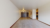 Located at 1800 US-51 in Stoughton, Wisconsin, this single-floor residence offers a practical and comfortable layout designed for everyday living. The open living area is generously sized, featuring neutral carpet, wood-look flooring near the entryway, a ceiling fan, and large white walls that create a bright, airy atmosphere. A pass-through opening connects the living space to the kitchen, enhancing the sense of openness throughout. The kitchen is well-equipped with dark espresso cabinetry, granite-style countertops, stainless steel appliances including a refrigerator and range, and a dedicated walk-in pantry for added storage. Wood-look flooring runs throughout the kitchen for easy maintenance. The unit includes two carpeted bedrooms, each with natural light from windows fitted with blinds and baseboard heating. One bedroom features a ceiling fan and a sliding-door closet, while the other offers generous closet space and houses a stacked in-unit washer and dryer for added convenience. The full bathroom includes a vanity with granite-style countertops, dark cabinetry, wood-look tile flooring, and a shower-tub combination. This residence provides a functional, move-in-ready living environment in a convenient Stoughton location.