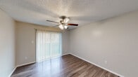 Located at 8926 N Lamar Blvd in Austin, Texas, this single-floor, two-bedroom, two-bathroom residence offers a practical and well-organized layout. Wood-look plank flooring runs throughout the home, providing a cohesive and easy-to-maintain surface. Textured ceilings are consistent across all rooms, adding a classic touch to the interior.

The open living area connects seamlessly to the kitchen, which features white cabinetry, a subway tile backsplash, dark countertops, a stainless steel sink, and black appliances including a refrigerator and electric range. A peninsula counter adds a functional workspace and casual dining option.

The primary bedroom is generously sized and includes a ceiling fan with light fixture, a sliding glass door with vertical blinds that allows natural light, and direct access to a closet and en-suite bathroom. The second bedroom also features a ceiling fan, a window with blinds, and ample floor space. Both bathrooms are equipped with tub-shower combinations featuring white tile surrounds and coordinating fixtures.

A connecting hallway links the bedrooms and bathrooms, keeping the private areas distinct from the main living spaces. The neutral color palette throughout creates a clean, move-in ready environment suited for a variety of living arrangements.
