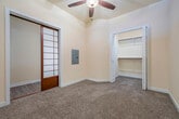 This single-floor, one-bedroom, one-bathroom residence offers a thoughtfully designed layout that maximizes its compact footprint. Upon entry, a welcoming hallway with warm hardwood-style flooring leads through the space, highlighted by a distinctive shoji-inspired sliding panel that adds an elegant architectural touch and a nod to Japanese design aesthetics.

The open living and kitchen area features light hardwood-style flooring throughout, creating a bright and cohesive feel. The kitchen is equipped with warm wood cabinetry, black appliances including a refrigerator and range, and a peninsula with a light-toned countertop that doubles as a breakfast bar, illuminated by stylish pendant lighting overhead.

The bedroom is a comfortable retreat, finished with durable hardwood-style flooring, a window with blinds that allows natural light to filter in, and a wall-mounted HVAC unit for independent climate control. A set of double doors opens to a dedicated closet, which features built-in shelving and hanging rods for organized storage.

The bathroom is clean and functional, outfitted with a full-size soaking tub and shower combination, a wood-toned vanity with a light countertop, and easy-to-maintain hard flooring. Neutral, warm tones throughout the residence create a calm and inviting ambiance.