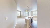 Located at 5239 S Rio Grande St in Littleton, Colorado, this single-floor, three-bedroom, two-bathroom home offers a well-designed layout with a comfortable and functional flow throughout. The open-concept kitchen and living area serves as the heart of the home, featuring rich dark cabinetry, white countertops, a kitchen island with a built-in sink and pendant lighting, and black appliances including a range, microwave, refrigerator, and dishwasher. Track lighting and hardwood-style flooring complete the kitchen, which opens seamlessly into a bright, carpeted living area bathed in natural light from multiple windows. Two hallways connect the bedrooms and bathrooms, maintaining a clean and organized circulation path. The spacious primary bedroom benefits from abundant natural light through large windows with outdoor views of surrounding greenery, and features a ceiling fan and soft carpeting. The secondary bedrooms are similarly well-lit with window views and plush carpet. The two bathrooms include hardwood-style flooring, vanities with white countertops, and a bathtub with shower. A dedicated in-unit laundry room with a stacked washer and dryer adds everyday convenience, rounding out this thoughtfully appointed home.