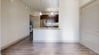 Located at 200 Philomena Dr in Kyle, TX, this one-bedroom, two-bathroom residence offers a well-designed single-floor layout that maximizes functionality and comfort. The open-concept living and kitchen area is anchored by a peninsula with granite countertops and pendant lighting, creating a natural gathering space. The kitchen is fully equipped with rich dark-brown cabinetry, stainless steel appliances including a refrigerator, range, and microwave, granite countertops, under-cabinet lighting, and a double sink — all finished with wood-style plank flooring for a cohesive look. The spacious bedroom features plush carpeting, a ceiling fan, and a window with natural light. The primary bathroom is appointed with a granite-topped vanity, dark cabinetry, tile surround soaking tub, and direct access to a dedicated walk-in closet. A second full bathroom provides added convenience. The in-unit laundry room accommodates a full-size washer and dryer. Additional highlights include a pantry for extra storage and a private balcony. Neutral tones and consistent finishes throughout create a clean, modern ambiance well-suited for comfortable everyday living.