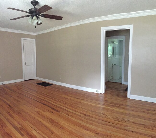 Spacious living room with coat closet, floor furnace, and doorway to bedrooms and bathroom - 1744 N Parkway