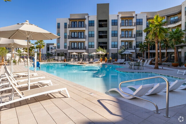Piscina estilo resort con entrada tipo playa, terraza para tomar sol y hamacas - Livano Avondale
