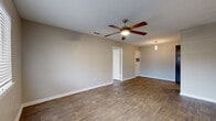 Located in Georgetown, TX, this single-story 2-bedroom, 3-bathroom home offers a functional and well-appointed layout. Throughout the home, warm wood-look flooring creates a cohesive and inviting atmosphere, complemented by neutral-toned walls and clean white baseboards.

The open living area is a comfortable gathering space featuring a ceiling fan with built-in lighting, a textured ceiling, and a window fitted with blinds that allow for natural light. The galley-style kitchen is efficiently designed with rich dark wood cabinetry, light countertops, a tile backsplash, and stainless steel appliances including a refrigerator, range, and microwave. Track lighting overhead ensures the kitchen is well-illuminated.

Both bedrooms carry the same warm flooring and neutral palette, each equipped with a ceiling fan. The primary bedroom offers a well-sized footprint, while the second bedroom provides comfortable accommodations. Three closets are distributed throughout the home for ample storage. The bathrooms feature clean white tiled tub-shower combinations.

Additional practical spaces include a dedicated laundry area and a utility room, adding convenience to daily living. The overall design is clean, consistent, and move-in ready, making this Georgetown home a practical and comfortable residence.