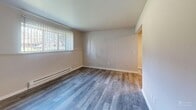 Located at 2345 Harrison Ave in East Lansing, Michigan, this one-bedroom, one-bathroom unit offers a well-organized layout across a single floor. Light-toned hardwood-style flooring runs throughout the space, providing a clean, cohesive look.

The kitchen is a standout feature, designed in a galley style with dark espresso cabinetry lining both sides, crisp white countertops, a stainless steel sink, and a full suite of stainless steel appliances including a range, microwave, and refrigerator. The kitchen opens toward the living area, enhancing the sense of flow between spaces.

The living room is bright and open, with neutral walls and a large window dressed with vertical blinds that allow natural light to fill the room. A wall-mounted air conditioning unit and a baseboard heater ensure year-round comfort.

The bedroom is a comfortable size, featuring a large window with vertical blinds for natural light and privacy, a baseboard heater, and a built-in closet with louvered bi-fold doors for convenient storage.

The bathroom includes a full tub and shower combination with white tile accented by yellow detail tiles, complemented by brushed nickel fixtures and a vanity with modern cabinetry. The entrance provides a practical transition into the main living areas, completing this efficiently designed unit.
