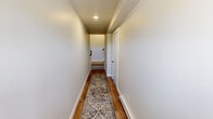 This well-appointed three-story home in Cedar Rapids, Iowa, offers a thoughtfully designed layout across three levels. The main living floor features an open-concept kitchen and living area bathed in natural light, with warm hardwood-style flooring throughout. The kitchen is outfitted with crisp white cabinetry, stainless steel appliances, a built-in microwave, and a two-toned island with a deep undermount sink and bar seating — ideal for both cooking and entertaining. The adjacent living room is bright and welcoming, with recessed lighting and windows that invite natural light. Sliding glass doors open onto a private balcony overlooking open, scenic prairie views — a standout feature of the home. Hallways on each floor are finished with the same hardwood-style flooring and recessed lighting, lending a cohesive, polished feel throughout. The two bedrooms feature plush carpeting and ceiling fans, with the generously sized primary bedroom accompanied by a dual-sink ensuite bathroom complete with white cabinetry and a large mirror. Additional bathrooms include a convenient half bath with a white vanity and hardwood-style flooring. The home's neutral color palette of soft grays and warm whites creates a clean, modern ambiance from entry to top floor.