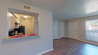 Located at 4330 Grand View in Odessa, Texas, this single-floor residence offers a practical and comfortable layout designed for everyday living. The open-concept living area is finished with rich, dark wood-look flooring that runs throughout the main living and dining spaces, creating a warm and cohesive atmosphere. A large window with vertical blinds allows natural light to fill the room, enhancing its bright and airy feel.

The kitchen is positioned adjacent to the living area and features a pass-through counter with a speckled granite-look surface, ideal for casual dining or entertaining. White cabinetry lines the walls from countertop to ceiling, providing ample storage space. Black appliances — including a refrigerator, electric range with overhead exhaust hood, and dishwasher — offer a clean contrast against the light cabinetry and countertops. A double-basin stainless steel sink completes the functional workspace.

The bedroom is carpeted for added comfort and includes a window with vertical blinds that invites natural light. The bathroom features a white undermount sink set in a speckled countertop, white cabinetry below, and a large mirror above. Textured ceilings are present throughout the space, adding a classic residential character. Multiple interior doors provide access to closets and additional storage, rounding out this well-appointed single-level home.