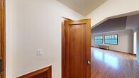 Located in Seattle's sought-after Queen Anne neighborhood, Unit 307 at 900 Queen Anne Ave N is a well-appointed residence that blends classic architectural character with practical living. Throughout the unit, warm hardwood floors extend seamlessly, reflecting natural light and lending a sense of continuity across the space. The living area is generously proportioned, featuring large windows framed with traditional millwork and a cast-iron radiator, offering views of the surrounding neighborhood rooftops. A charming arched doorway adds an elegant, period-appropriate architectural detail connecting the living spaces. The kitchen is laid out in a classic galley configuration, equipped with white cabinetry accented by brass hardware, a stainless steel sink, electric range, and hexagonal tile flooring, providing efficient use of space. The bedroom includes a closet with built-in wire shelving, and the unit also features a spacious walk-in closet with wire rack storage along multiple walls. The bathroom retains its vintage character with classic white subway tile wainscoting, a black-and-white mosaic tile floor, and a crisp white palette. Rich wood interior doors with traditional panel detailing complete the timeless aesthetic of this well-maintained Seattle residence.