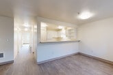 Located at 10110 19th Ave SE in Everett, WA, this single-floor, 3-bedroom, 2-bathroom unit offers a practical and comfortable layout designed for everyday living. The open-concept living and kitchen area serves as the heart of the home, where a pass-through peninsula counter connects the two spaces seamlessly. The kitchen features white cabinetry, built-in open shelving, and a white appliance suite, providing ample storage and a clean, functional aesthetic. Wood-style hard flooring runs throughout the main living areas, adding warmth and durability.

A central hallway lined with sliding-door closets leads to the three bedrooms, each finished with plush carpet flooring and generous natural light. The primary bedroom is a comfortable size and benefits from dedicated closet space. Additional bedrooms also include closet storage, making organization straightforward. One bathroom features accessibility-friendly grab bars around the tub and toilet, alongside a vanity and wood-style flooring.

The living area opens directly to the outdoors through a glass door, offering views of a grassy exterior area and providing convenient ground-level access. The unit's neutral color palette throughout creates a bright, clean canvas ready for personalization.