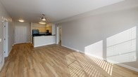 Located at 95 Burnett Ave S, Unit 315 in Renton, WA, this single-floor residence combines modern finishes with a functional, open layout. Light-toned hardwood-style flooring runs throughout the unit, creating a cohesive and inviting atmosphere.

The open-concept living area is generously sized, bathed in natural light through large windows fitted with blinds, and features a ceiling fan for added comfort. It flows seamlessly into the kitchen, which serves as a central hub of the home. The kitchen is equipped with warm-toned cabinetry, dark granite-style countertops, black appliances including a refrigerator, range, microwave, and dishwasher, and a peninsula that doubles as a breakfast bar.

The bedrooms are well-proportioned and bright, with one featuring direct access to a dedicated bathroom and a walk-in closet. The unit includes two bathrooms: one with a dual-sink vanity featuring light wood cabinetry and a white countertop, and a second full bathroom with a tub/shower combo and a tiled vanity. Both bathrooms continue the light wood flooring aesthetic.

Additional highlights include a walk-in closet, ample storage throughout, and a clean, neutral color palette that suits a variety of interior styles. The layout is practical and efficient, making the most of the available space.