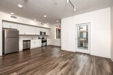 Located at 825 Bluegrass Circle in Cedar Falls, Iowa, this single-floor home offers four bedrooms and two full bathrooms within a thoughtfully designed layout. Wood-look vinyl flooring runs consistently throughout, lending a cohesive and modern aesthetic to every room.

The combined kitchen and living area serves as the heart of the home. The kitchen is outfitted with white shaker-style cabinetry, white quartz countertops, and a full suite of stainless steel appliances, including a refrigerator, electric range, built-in microwave, and dishwasher. Recessed lighting and a window overlooking the exterior keep the space bright and functional. The adjoining living area features track lighting and access to natural light through a large window.

Four bedrooms provide flexible accommodation options. The primary bedroom is a well-proportioned room with wood-look flooring and direct access to one of the bathrooms, which includes a shower-tub combination. The additional bedrooms feature closets and the same consistent flooring. A second bathroom is finished with a white vanity, a large mirror, and matching hardware.

A central hallway connects all rooms efficiently, with ceiling-mounted HVAC vents ensuring climate comfort throughout. The clean, neutral color palette and modern fixtures give the home a fresh, move-in-ready appeal.