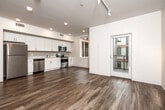 Located at 825 Bluegrass Circle in Cedar Falls, Iowa, this single-floor home offers four bedrooms and two full bathrooms within a thoughtfully designed layout. Wood-look vinyl flooring runs consistently throughout, lending a cohesive and modern aesthetic to every room.

The combined kitchen and living area serves as the heart of the home. The kitchen is outfitted with white shaker-style cabinetry, white quartz countertops, and a full suite of stainless steel appliances, including a refrigerator, electric range, built-in microwave, and dishwasher. Recessed lighting and a window overlooking the exterior keep the space bright and functional. The adjoining living area features track lighting and access to natural light through a large window.

Four bedrooms provide flexible accommodation options. The primary bedroom is a well-proportioned room with wood-look flooring and direct access to one of the bathrooms, which includes a shower-tub combination. The additional bedrooms feature closets and the same consistent flooring. A second bathroom is finished with a white vanity, a large mirror, and matching hardware.

A central hallway connects all rooms efficiently, with ceiling-mounted HVAC vents ensuring climate comfort throughout. The clean, neutral color palette and modern fixtures give the home a fresh, move-in-ready appeal.