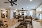 This well-appointed single-story home in Jackson, Tennessee offers a thoughtfully designed layout with 2 bedrooms and 3 bathrooms. The welcoming entrance hallway sets the tone with light wood-look flooring, recessed lighting, and a neutral palette that flows seamlessly throughout the home. The open-concept kitchen and dining area is a standout, featuring white shaker cabinetry, subway tile backsplash, stainless steel appliances, a large island with a matte black faucet, and pendant lighting. The dining nook is bathed in natural light from multiple windows. The living room is a relaxed, comfortable space with recessed lighting and a ceiling fan. The spacious primary bedroom is a serene retreat, highlighted by a four-poster upholstered bed, ceiling fan, natural light from windows, and direct access to an ensuite bath. The primary bathroom impresses with a freestanding soaking tub, a glass-enclosed subway tile shower with matte black fixtures, and light hardwood flooring. A dedicated laundry room houses full-size front-loading washer and dryer units. Two closets, two hallways, and a convenient entrance complete this refined and functional home.