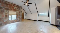 This 750 sq ft apartment blends historic charm with modern convenience. The open-concept living area showcases exposed brick walls and soaring ceilings with exposed beams, creating an industrial-chic ambiance. The kitchen boasts dark wood cabinetry, granite countertops, and stainless steel appliances. The spacious 180 sq ft bedroom offers ample natural light through skylights. The bathroom features a clean, white design with a combined tub and shower. Throughout, cracked concrete floors add character, while sliding barn doors and strategically placed lighting fixtures enhance the urban loft aesthetic. The apartment's unique layout and architectural elements make efficient use of the space, offering a stylish and functional urban living experience.