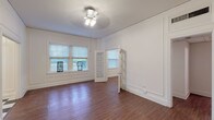 Located in the historic Central West End neighborhood of St. Louis, Missouri, this single-floor unit at 5272-86 Washington Place blends classic architectural character with functional living spaces. Throughout the main living areas, rich hardwood flooring anchors the rooms, complemented by crisp white walls adorned with elegant raised panel molding details that speak to the building's timeless design heritage. Natural light filters in generously through multiple windows fitted with blinds, creating a bright and welcoming ambiance. A charming French door with glass panes connects the living spaces, adding an open, airy feel to the floor plan. Ceiling light fixtures are centrally placed in each room, providing ample illumination. The kitchen features classic black-and-white checkered tile flooring, white cabinetry with ample storage, light countertops, a stainless steel sink, a dishwasher, and a full-size refrigerator — offering a clean and efficient cooking space. The bathroom includes a full bathtub with surround walls and a window that brings in natural light. Closet space is thoughtfully integrated throughout, with paneled double doors maintaining the cohesive aesthetic. The overall atmosphere is clean, classic, and full of character, reflecting the architectural charm synonymous with St. Louis's storied residential buildings.