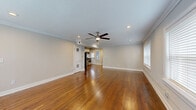 Located at 216 Emanuel Cleaver II Blvd in Kansas City, MO, this single-floor residence combines classic architectural detailing with thoughtful modern updates. Rich hardwood floors flow consistently throughout the home, complemented by crisp white crown molding and neutral-toned walls that create a bright, cohesive aesthetic.

The open living area is generously proportioned, featuring recessed lighting, a ceiling fan, and multiple windows dressed with horizontal blinds that allow for ample natural light. The space connects seamlessly to the kitchen, which has been updated with white shaker-style cabinetry, a white subway tile backsplash, dark countertops, stainless steel appliances including a gas range, dishwasher, microwave, and refrigerator, and a modern sink fixture.

The bedrooms continue the warm hardwood flooring and crown molding found throughout, with ceiling fans and windows providing ventilation and natural light. Each room offers a clean, versatile canvas with well-maintained white panel doors and trim.

The bathroom stands out as a refined feature, showcasing a tiled walk-in shower with classic white subway tile, an accent band of gray tile, a hexagonal mosaic floor, built-in niches, and a small window for natural light. A white vanity and large mirror complete the space. Overall, the home presents a well-maintained, move-in ready environment with timeless character.