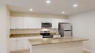 This thoughtfully designed 2-bedroom, 2-bathroom residence in Columbia, SC delivers a functional and modern living experience across a single floor. The open-concept kitchen and living area serves as the heart of the home, featuring a large granite-topped island with an undermount sink, crisp white shaker cabinetry extending to the ceiling, and a full suite of stainless steel appliances including a range, over-the-range microwave, and refrigerator. Light wood-style flooring flows throughout the main living areas, complemented by recessed lighting and ceiling fans that enhance both style and comfort. The living room benefits from abundant natural light through a large window and sliding glass door with vertical blinds, creating a bright and airy atmosphere. Both bedrooms are carpeted and feature ceiling fans with light fixtures and ample natural light from windows. The spacious primary bedroom includes a large window with outdoor views. Each of the two bathrooms mirrors the home's design continuity with granite countertops, white cabinetry, and light wood-style flooring. One bathroom features a walk-in shower, while the other offers a full shower-tub combination. Two dedicated closets provide generous storage throughout the residence.