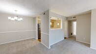This single-floor residence offers a functional and well-organized layout across three bedrooms and two bathrooms. The living room serves as a central gathering space, highlighted by a fireplace with a classic surround and a sliding glass door that admits generous natural light and provides outdoor views. Neutral-toned carpet flows throughout the main living areas, complementing the warm, understated color palette of the walls.

The dining area adjoins the living space and features a chandelier overhead, creating a defined area for meals. A half-wall pass-through connects the dining room to the kitchen, which is equipped with gray cabinetry, white quartz-style countertops, a subway tile backsplash, stainless steel appliances including a refrigerator and dishwasher, and wood-look flooring.

The bedrooms are carpeted and receive natural light through double windows fitted with blinds. The primary bedroom includes a spacious closet with built-in wire shelving. Both bathrooms feature wood-look flooring; one includes a tub-shower combination, while the other offers a vanity with gray cabinetry and a large mirror. A hallway and dedicated closet space complete the layout, contributing to the overall practicality of the home.