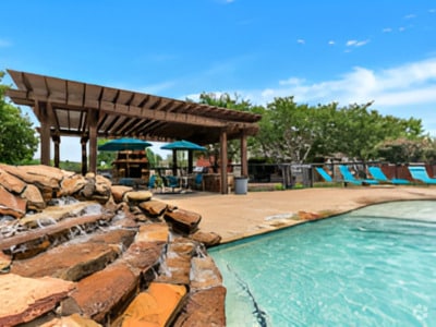 Resort-style swimming pool surrounded by lounge seating and greenery—a perfect summer escape. - Bent Tree Park Apartments