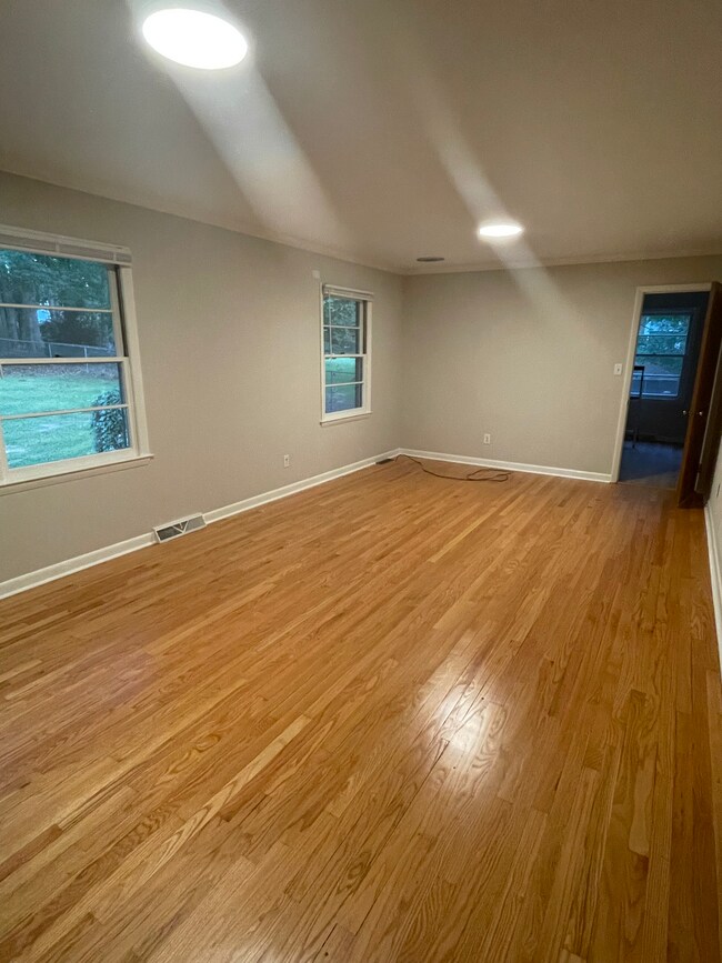Sala de estar con vista al patio trasero y pisos de madera noble restaurados. - 2112 Kilburn Rd