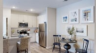 This single-floor residence at 1090 Summersweet Dr in New Bern, NC offers a cohesive, modern design highlighted by light wood-look flooring that flows consistently throughout the space. The open-concept kitchen is outfitted with white shaker-style cabinetry, granite countertops, a subway tile backsplash, and stainless steel appliances, including a refrigerator, range, and microwave. A dining area adjacent to the kitchen provides an intimate setting for meals.

The living room is comfortably sized, featuring a wall-mounted television setup and access to additional rooms via paneled interior doors. Two bedrooms offer comfortable retreats; the primary bedroom includes a ceiling fan, a walk-in closet with wire shelving systems, and a window that allows natural light. A second bedroom provides additional flexibility for guests or other uses.

The bathroom features granite countertops, white cabinetry, recessed lighting, and a tiled shower-tub combination with a window for natural light. A dedicated laundry room accommodates a full-size washer and dryer with overhead shelving for storage. Neutral wall tones and consistent finishes throughout contribute to the space's clean, unified aesthetic.