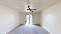 Located at 7290 Penzance Blvd in Fort Myers, Florida, this single-story home offers a well-organized layout with four bedrooms, two bathrooms, a living room, and a kitchen. The living room is a comfortable, open space featuring soft carpeting, a ceiling fan with light fixture, and a sliding glass door that fills the room with natural light and provides outdoor views. The kitchen is equipped with white cabinetry, granite-style countertops, a double sink, and white appliances including a range and refrigerator, all complemented by wood-look flooring and a window that brings in additional natural light. The bedrooms are carpeted and each includes a ceiling fan, with the primary bedroom offering generous proportions. The two bathrooms are clean and functional — one features a tub/shower combo with a vanity and wood-look flooring, while the second includes a glass-enclosed shower stall with tiled walls. Neutral, light-toned walls throughout the home create a bright and airy atmosphere. Hallways connect the rooms efficiently, and a dedicated closet provides additional storage. The home's straightforward single-floor design makes it practical and accessible, while its Fort Myers location offers the benefits of Southwest Florida living.