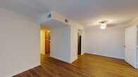 This single-floor residence in Louisville, Kentucky offers a practical and comfortable layout with a clean, neutral aesthetic throughout. The open living area features durable wood-style flooring and crisp white walls, creating a bright and welcoming atmosphere. A ceiling light fixture adds a decorative touch to the space, while multiple entryways connect seamlessly to the kitchen and additional rooms.

The kitchen is well-appointed with warm-toned wood cabinetry, granite-style countertops, and stainless steel appliances including a range, over-the-range microwave, and refrigerator, complemented by a dishwasher. Wood-style flooring continues through this space, adding visual consistency.

The bedrooms are carpeted for comfort and feature neutral walls with blinds-covered windows that allow for natural light while maintaining privacy. The larger bedroom benefits from corner windows on two walls, enhancing its bright and airy feel.

Two bathrooms serve the unit, each featuring wood-style flooring, wood-toned vanity cabinetry, and light countertops. One bathroom includes a shower-tub combination with clean white surround, while the other offers a more compact layout with practical fixtures throughout.